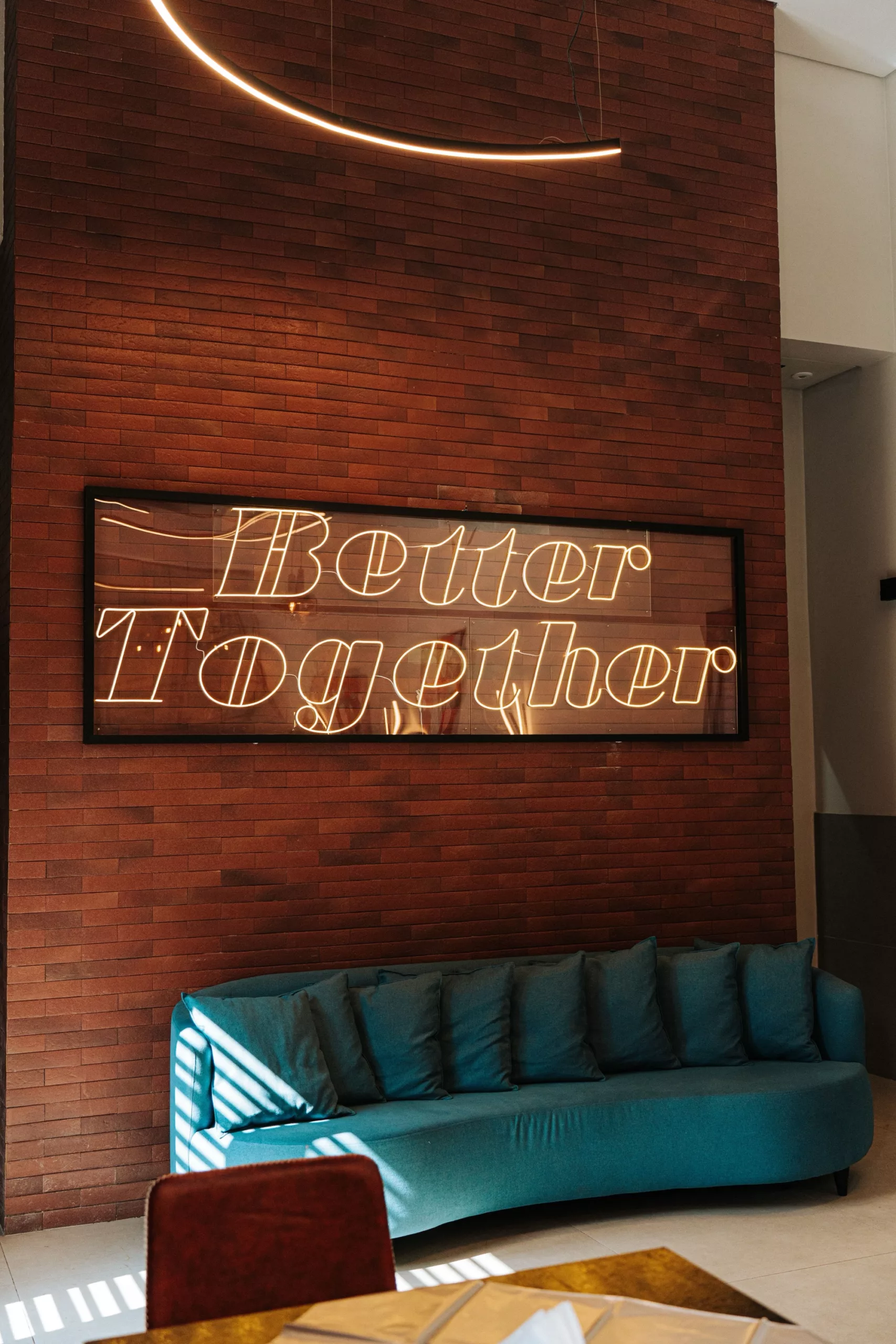 Glowing neon sign on the wall of a cozy modern living room above a sofa